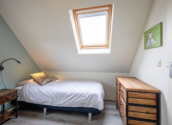 Gezellige woonkamer van Vakantiehuisje in Den Burg, Texel met comfortabele zithoek en uitzicht op de tuin, ideaal voor ontspanning.