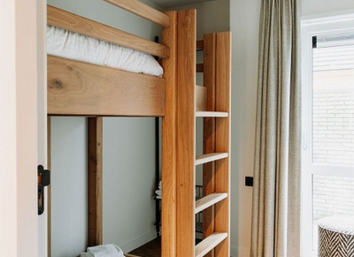 Gemuetliche Sitzecke im Luxury Apartment 4p, Den Burg, Texel mit stilvoller Rattanlampe und frischen Blumen.