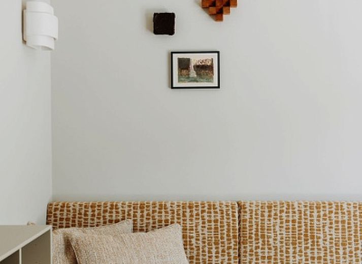 Gemuetliche Sitzecke im Luxury Apartment 4p, Den Burg, Texel mit stilvoller Rattanlampe und frischen Blumen.