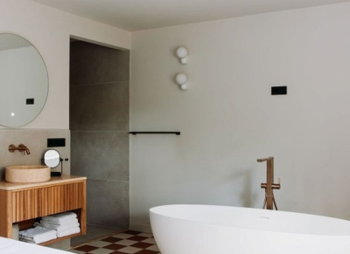 Moderne badkamer in Wellness Appartement 6p, Den Burg, Texel met vrijstaand bad en stijlvolle inrichting.