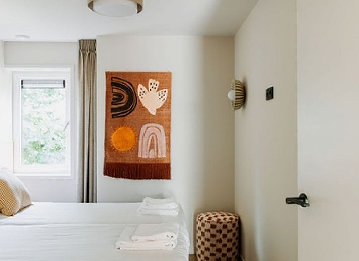 Gezellige woonkamer in Wellness Appartement 6p, Den Burg, Texel met comfortabele bank en veel natuurlijk licht.