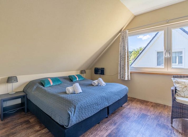 Gezellige woonkamer van Huisje in Den Burg, Texel met comfortabele banken en uitzicht op de tuin.