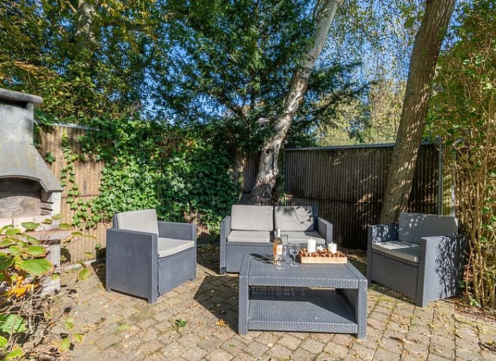 Ruime zitkamer in Huisje in Den Burg, Texel met grote ramen en veel natuurlijk licht.