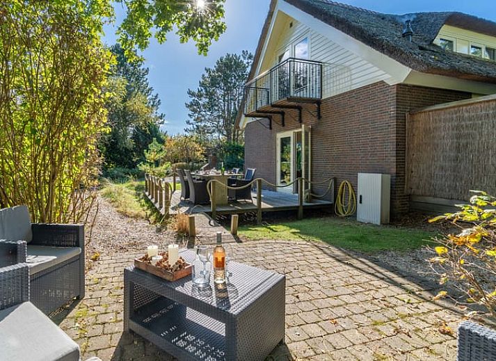 Ruime zitkamer in Huisje in Den Burg, Texel met grote ramen en veel natuurlijk licht.