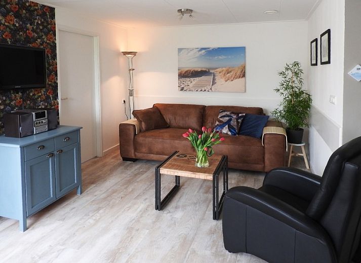 Gemuetlicher Garten im Bungalow der Familie Smit in Den Burg, Texel, mit bunten Blumen und gruenen Hecken.