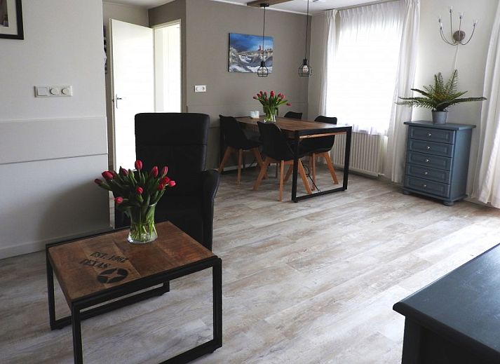 Gemuetlicher Garten im Bungalow der Familie Smit in Den Burg, Texel, mit bunten Blumen und gruenen Hecken.