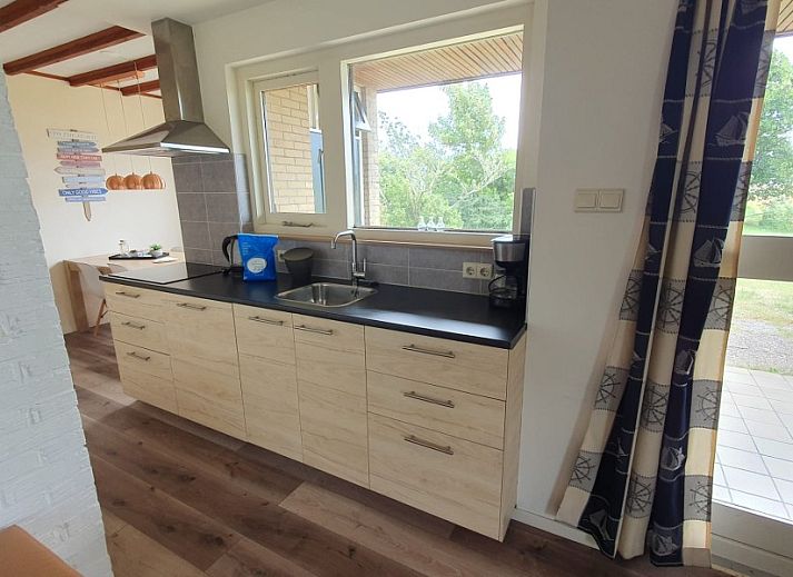 Gemuetliches Wohnzimmer des Bungalows Weizicht in Dennenbos, Texel mit Blick auf die Natur.