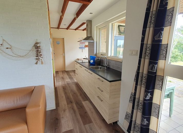 Gemuetliches Wohnzimmer des Bungalows Weizicht in Dennenbos, Texel mit Blick auf die Natur.