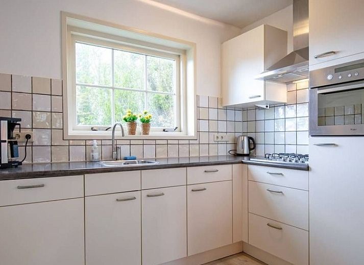 Eingang zum Ferienhaus 5 Persoons in Den Burg Texel, umgeben von einer gruenen Umgebung auf den Watteninseln.