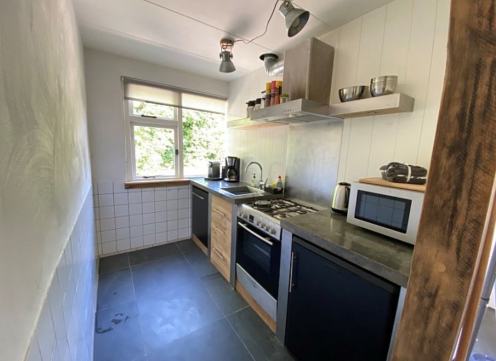 Kogerstraat 98A vakantiehuis met terras in Den Burg, Texel, omgeven door groene natuur.