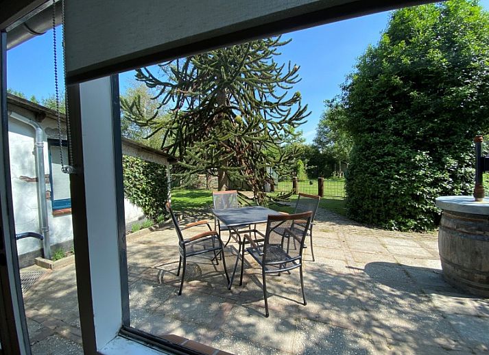 Gezellige woonkamer van Kogerstraat 98A in Den Burg, Texel, met houten meubels en een ruime zithoek.