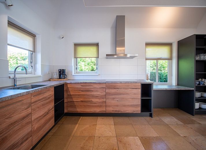 Vooraanzicht van Korenmolen vakantiehuis in Den Burg, Texel met weelderige tuin.