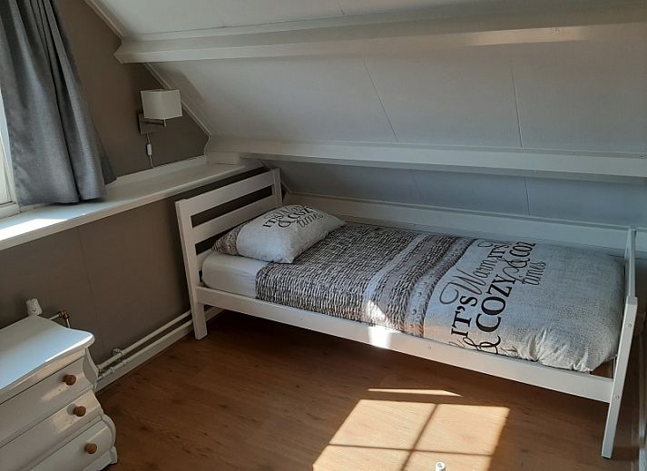 Spacious terrace at De Molen, vacation home in Den Burg, Texel, with garden furniture and flowers.