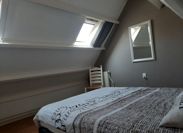 Spacious terrace at De Molen, vacation home in Den Burg, Texel, with garden furniture and flowers.