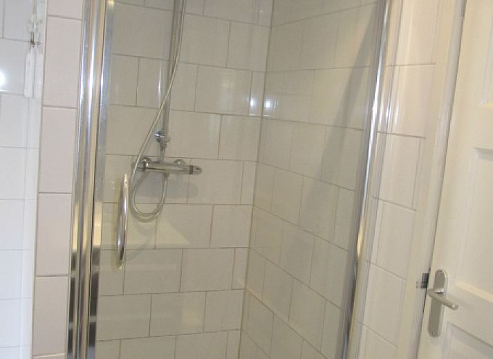 Spacious terrace at De Molen, vacation home in Den Burg, Texel, with garden furniture and flowers.