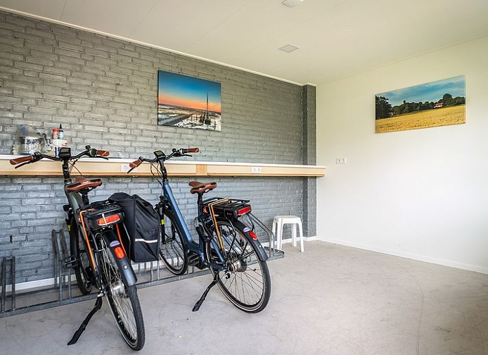 Gezellige woonkamer van Appartement De Kwikstaart, Den Burg, Texel, met comfortabele zitruimte en warme houten accenten.