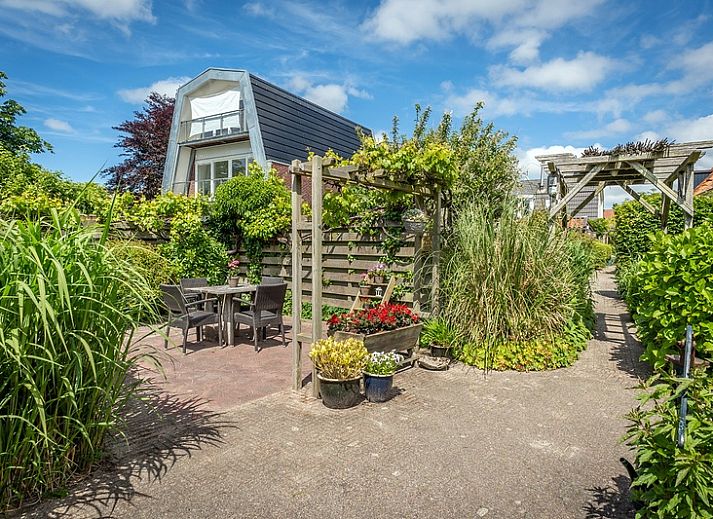 Gezellige woonkamer van Appartement De Kwikstaart, Den Burg, Texel, met comfortabele zitruimte en warme houten accenten.