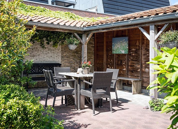 Gezellige woonkamer van Appartement De Kwikstaart, Den Burg, Texel, met comfortabele zitruimte en warme houten accenten.