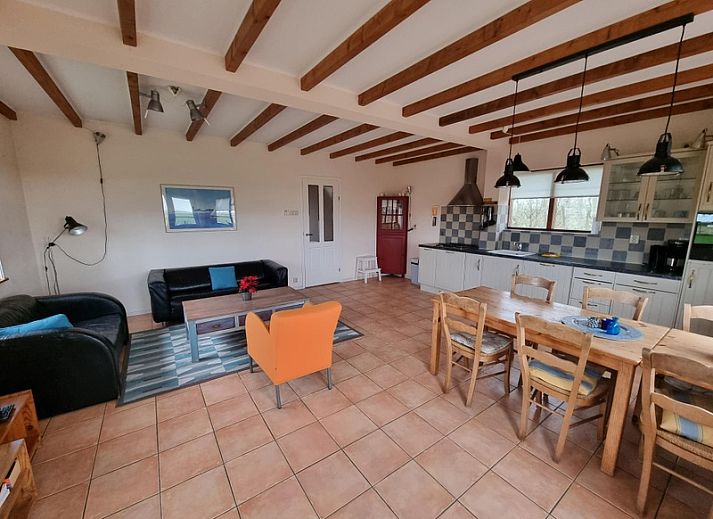Vakantiehuis Duinzicht in Den Burg, Texel, biedt een charmante houten gevel met uitzicht op de groene natuur van de Waddeneilanden.