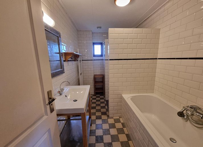 Zijaanzicht van Vakantiehuis Duinzicht in Den Burg, Texel, met een uitnodigend pad en een ruim grasveld.