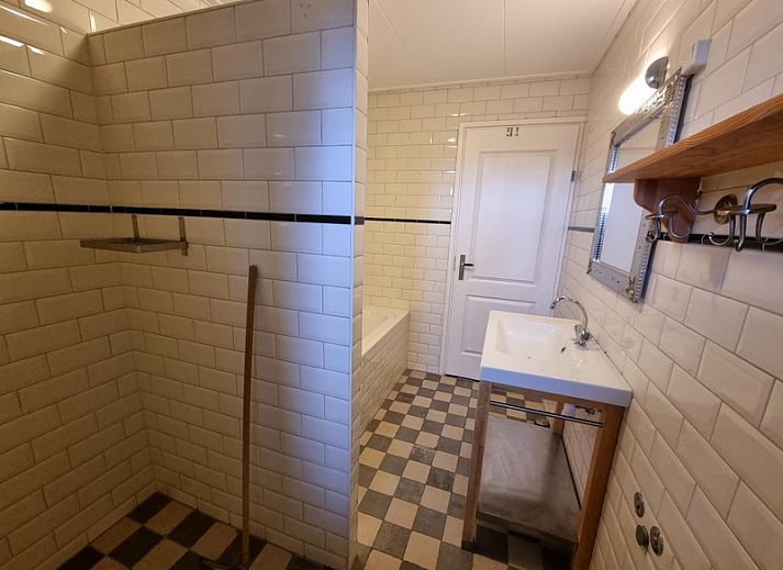 Zijaanzicht van Vakantiehuis Duinzicht in Den Burg, Texel, met een uitnodigend pad en een ruim grasveld.
