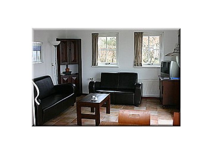 Malerisches Aeusseres von De Ark, Ferienhaus in Den Hoorn, Texel mit gruenen Fassaden.