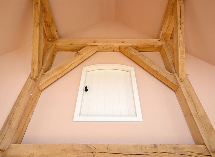 Gemuetliches Wohnzimmer im Ferienhaus Kamille in Den Hoorn auf Texel mit komfortabler Sitzecke und Blick auf die gruene Umgebung.