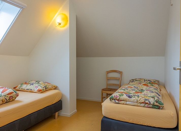 Gemuetliches Wohnzimmer im Apartment Yellow, einem Ferienhaus in Den Hoorn, Texel, mit bequemen Sitzgelegenheiten und rustikaler Einrichtung.