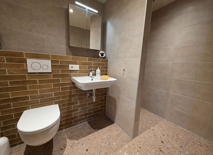 Gemuetliches Wohnzimmer im Apartment Yellow, einem Ferienhaus in Den Hoorn, Texel, mit bequemen Sitzgelegenheiten und rustikaler Einrichtung.