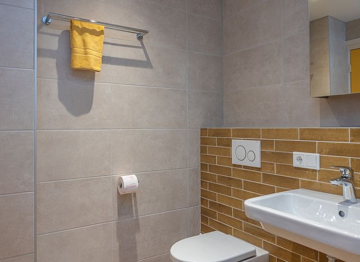 Gemuetliches Wohnzimmer im Apartment Yellow, einem Ferienhaus in Den Hoorn, Texel, mit bequemen Sitzgelegenheiten und rustikaler Einrichtung.