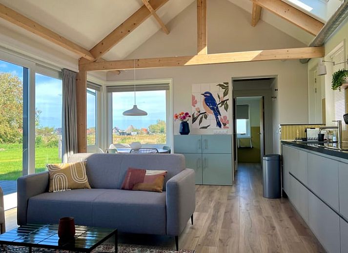 Ferienhaus in Den Hoorn auf Texel, umgeben von ueppiger Natur und gruenen Feldern.