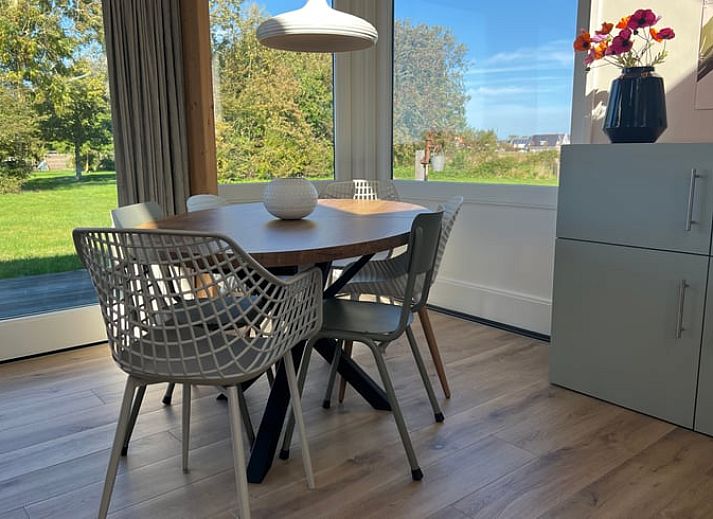 Ferienhaus in Den Hoorn auf Texel, umgeben von ueppiger Natur und gruenen Feldern.