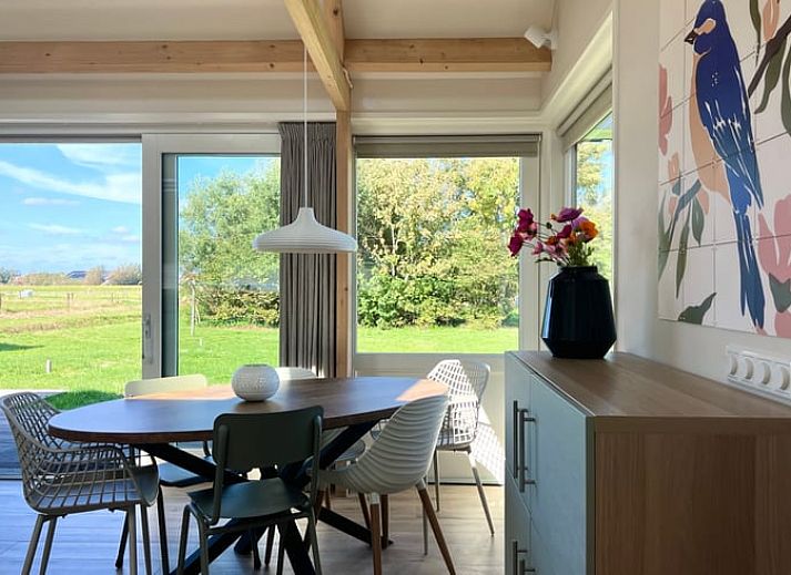 Ferienhaus in Den Hoorn auf Texel, umgeben von ueppiger Natur und gruenen Feldern.