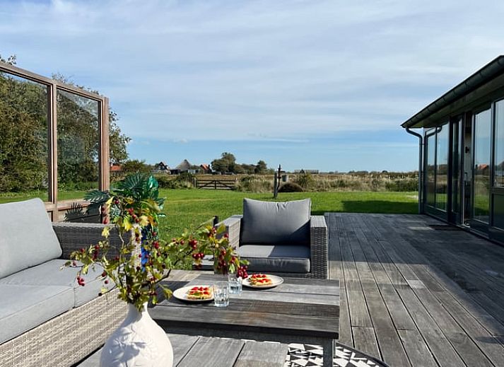 Essecke im Ferienhaus in Den Hoorn, Texel, mit Blick auf die gruene Landschaft.