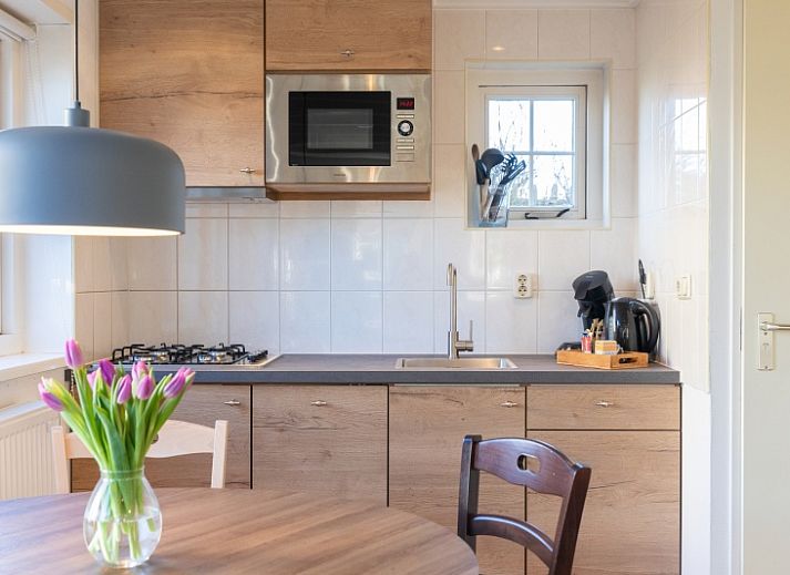 Gezellig terras bij Duiventil vakantiehuis in Den Hoorn Texel met bloemen en zitplaatsen.