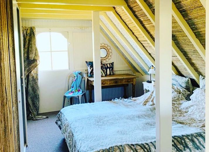 Gemuetliche Veranda im Ferienhaus 't Kaaps Huussie in Oosterend, Texel, ideal fuer entspannende Momente im Freien.