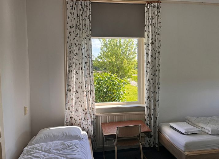 Gemuetlicher Garten des Ferienhauses De Viersprong in Oosterend, Texel mit Terrasse und ueppiger Natur.