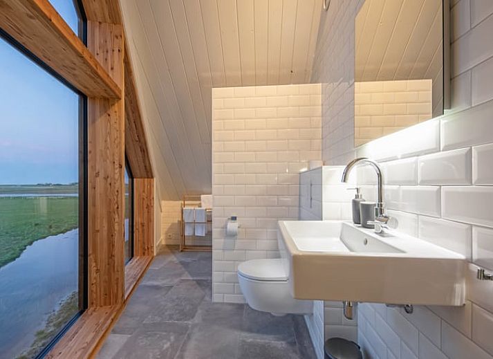 Gezellige woonkamer in Vakantiehuis in Oosterend, Texel met panoramisch uitzicht op de natuur.