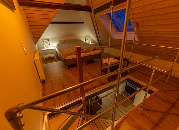 Holzschild mit der Aufschrift "Gaestehaus" an einem Ferienhaus in Oosterend, Texel, umgeben von Gruenanlagen.