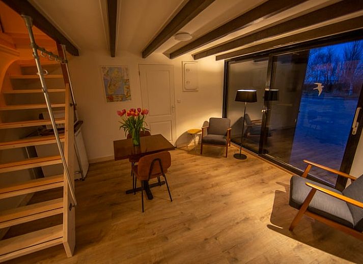 Holzschild mit der Aufschrift "Gaestehaus" an einem Ferienhaus in Oosterend, Texel, umgeben von Gruenanlagen.