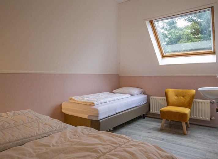 Moderne woonkamer in vakantiehuis Nieuwlanderweg 69, De Koog, Texel, met comfortabele zithoek en veel natuurlijk licht.