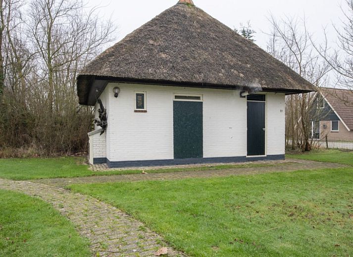 Moderne woonkamer in vakantiehuis Nieuwlanderweg 69, De Koog, Texel, met comfortabele zithoek en veel natuurlijk licht.