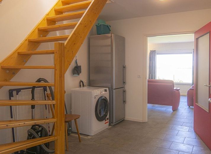 Dining area in vacation home Nieuwlanderweg 69, De Koog, Texel, with round table and garden view for cozy meals.