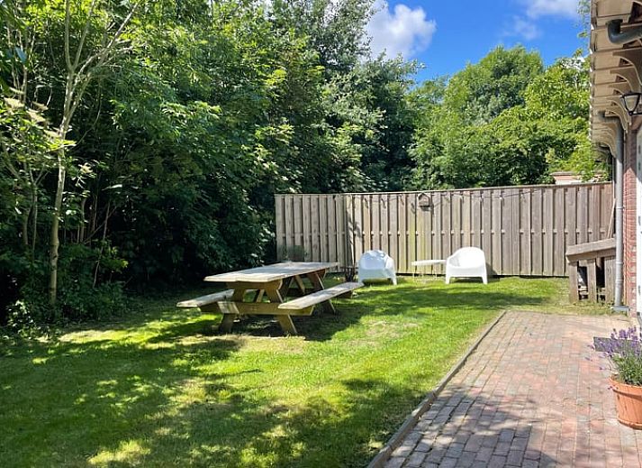 Geniessen Sie den gruenen Garten des Ferienhauses in Oosterend Texel, Watteninseln, mit Picknicktisch und Sitzgelegenheiten.