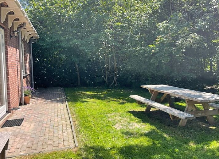 Geniessen Sie den gruenen Garten des Ferienhauses in Oosterend Texel, Watteninseln, mit Picknicktisch und Sitzgelegenheiten.