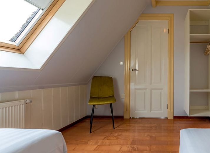 Gezellige woonkamer in Vakantiehuis Oosterend Texel met comfortabele zitplaatsen en een houtkachel, ideaal voor ontspanning.