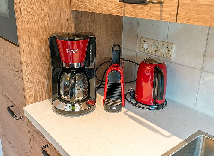 Gezellige woonkamer van Gouden Rijder vakantiehuis in Oosterend, Texel, met comfortabele banken en een eetgedeelte.