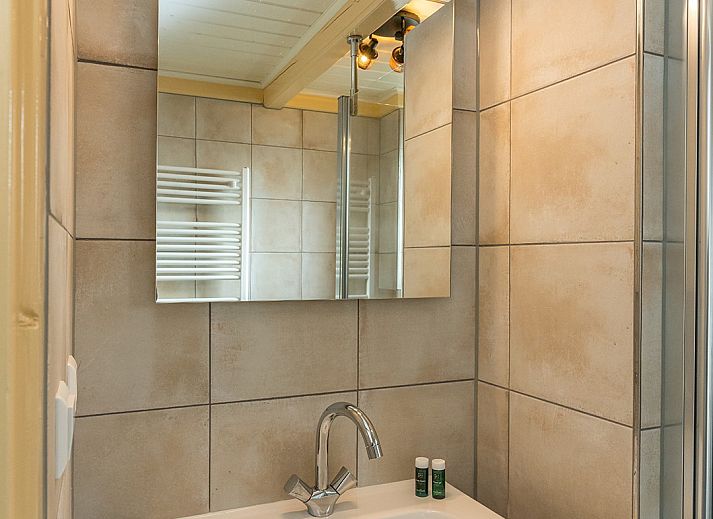 Gezellige woonkamer van Gouden Rijder vakantiehuis in Oosterend, Texel, met comfortabele banken en een eetgedeelte.