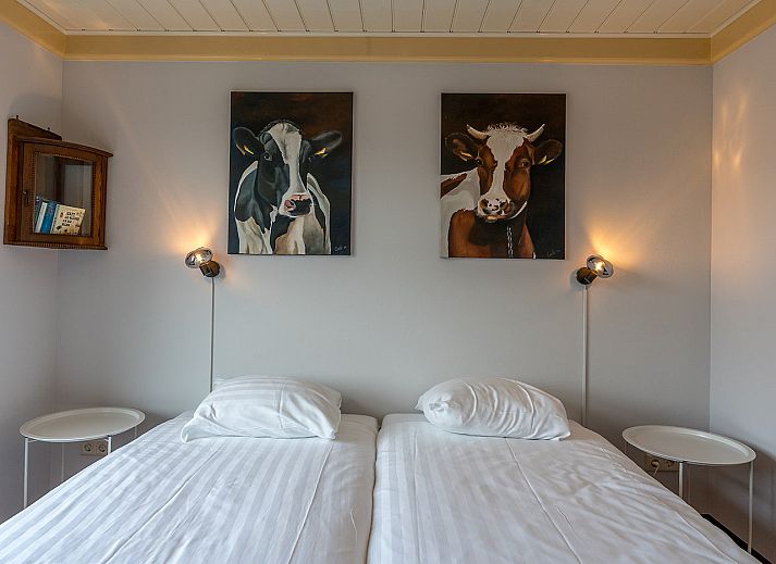 Gezellige woonkamer van Gouden Rijder vakantiehuis in Oosterend, Texel, met comfortabele banken en een eetgedeelte.