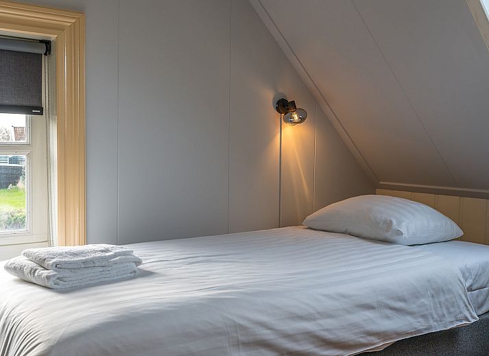 Open keuken en eetkamer in Gouden Rijder vakantiehuis, Oosterend, Texel, met een houtkachel voor extra sfeer.